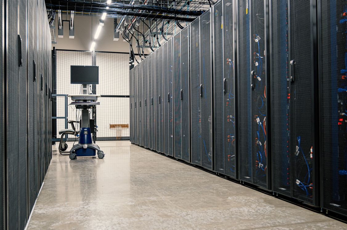 Steel framework server cabinets with networking devices and cables in a data center.